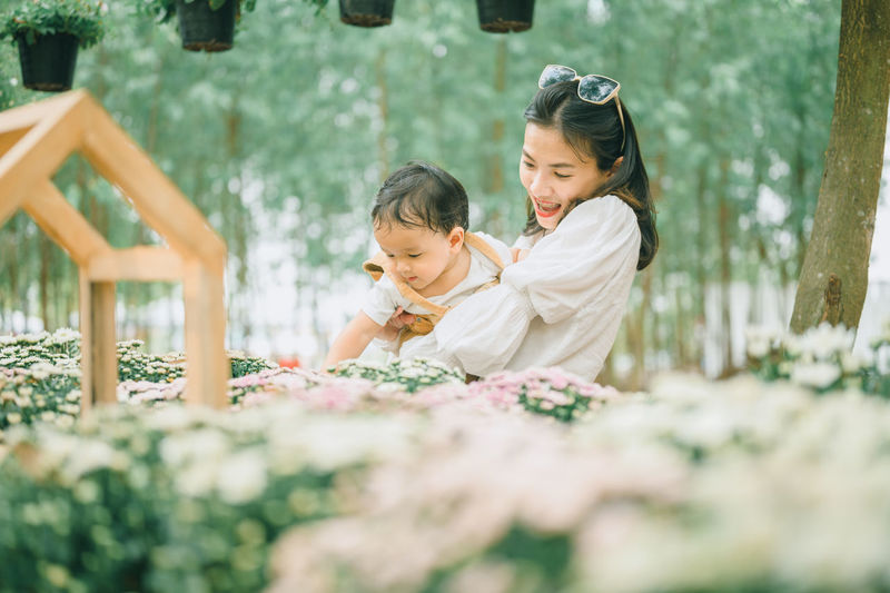 Girl looking away while standing against plants