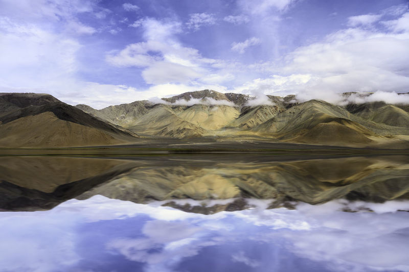 Scenic view of mountain range reflecting in lake