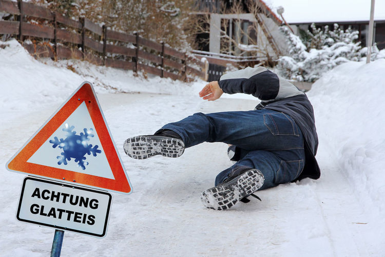 Senior man falling on snow covered land