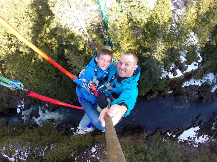 Father and son hanging from rope