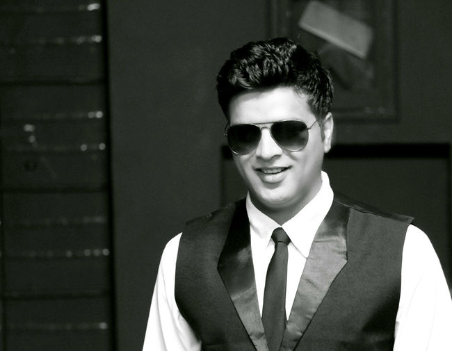 Handsome smiling man wearing waistcoat and sunglasses