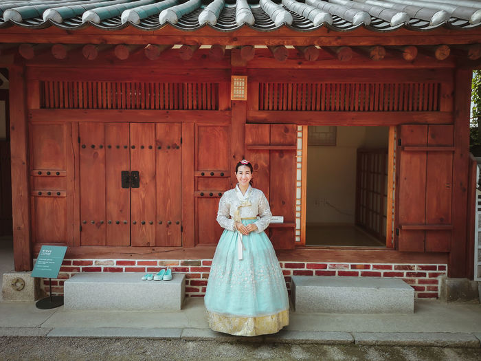 Portrait of woman standing against korean building 