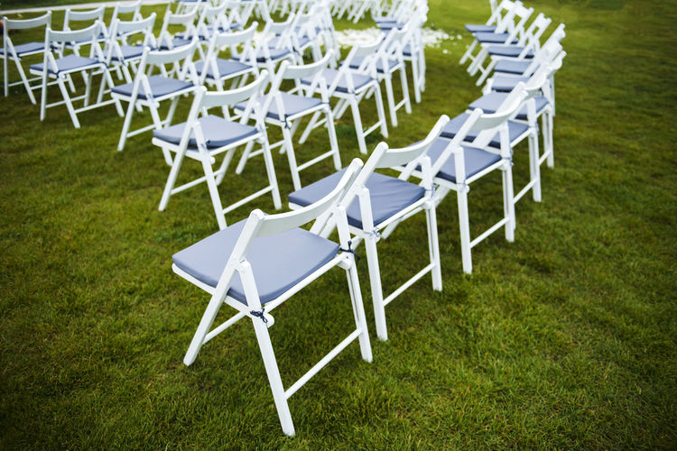 EMPTY CHAIRS AND TABLES IN FIELD