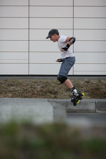 Full length of boy roller skating on footpath