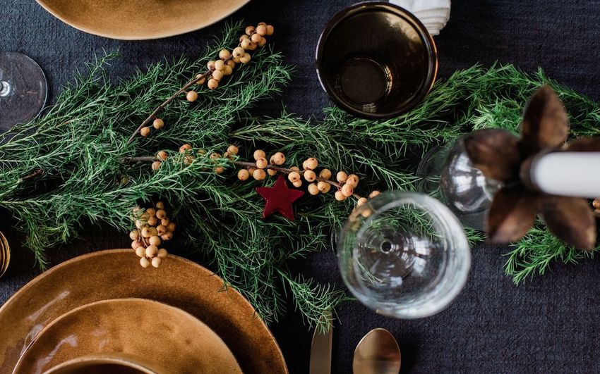 Greenery and berries on a decorated festive dinner table
