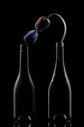Close-up of glass bottle against black background