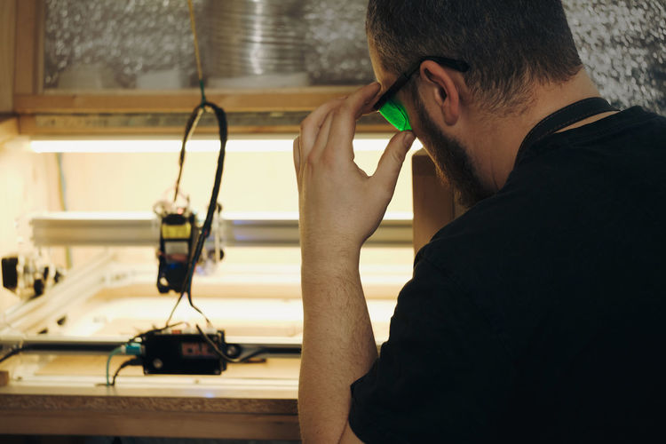 Side view of young man using mobile phone