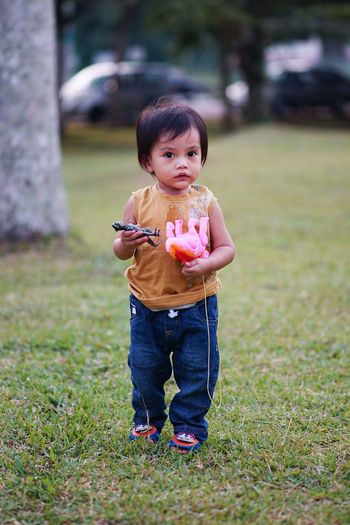 Portrait of cute boy holding grass