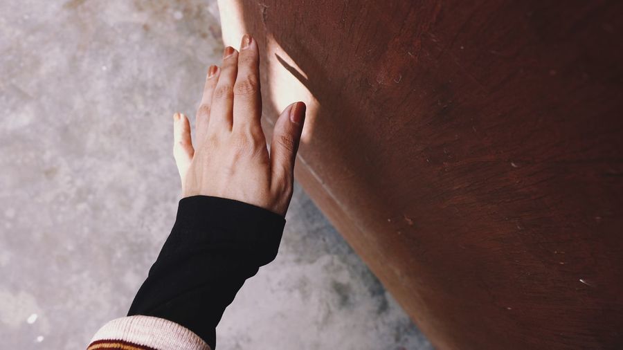 Close-up of hands against wall