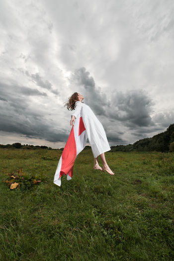 Woman standing on field against sky