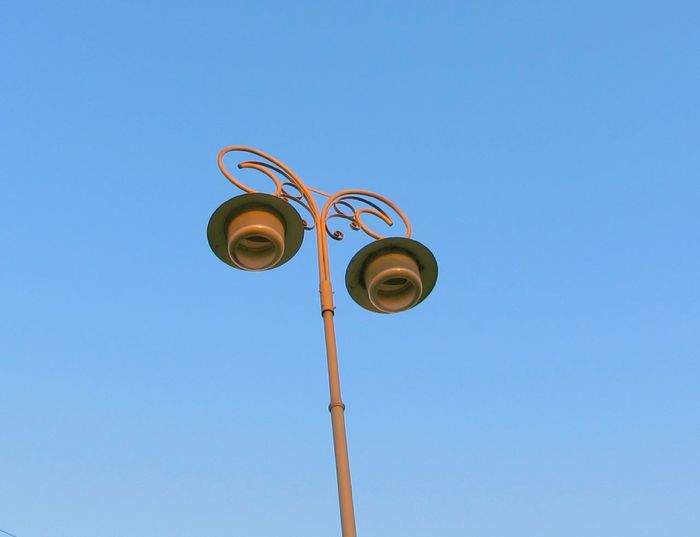 Low angle view of lamp post against clear blue sky