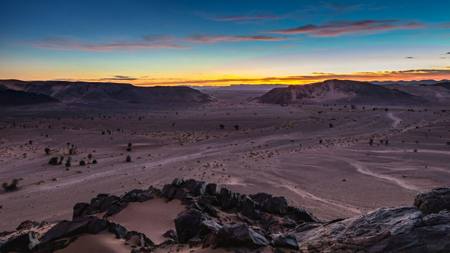 Scenic view of desert against sky during sunset