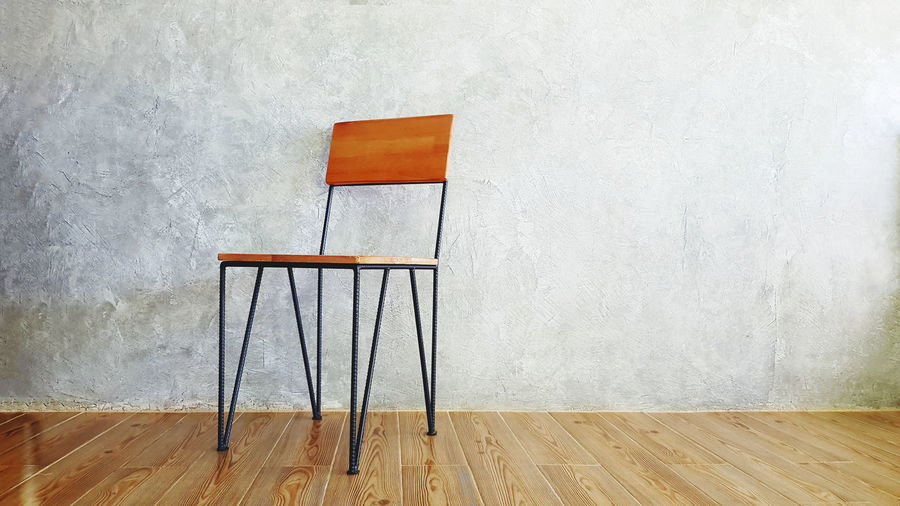 Empty chair on table against wall at home