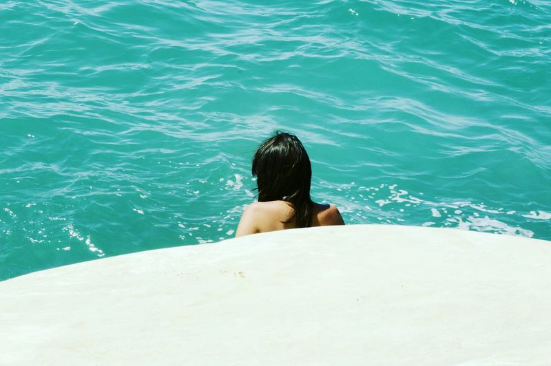 Rear view of woman swimming in sea