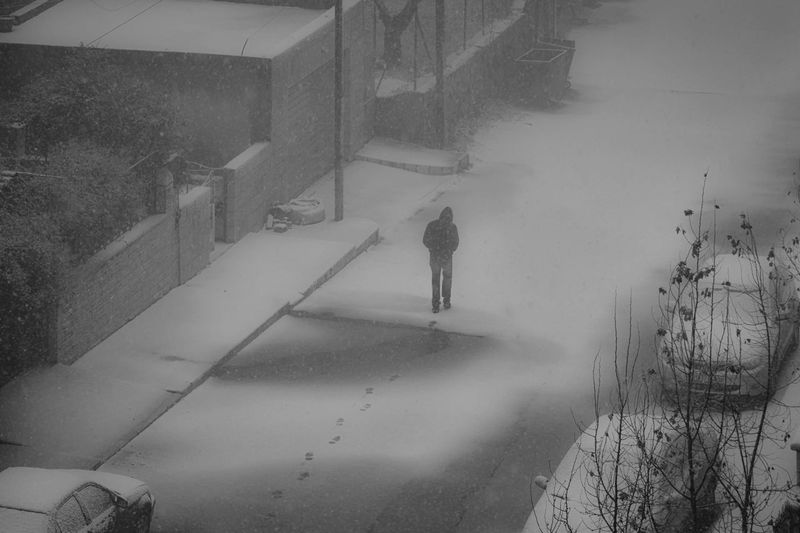 High angle view of man walking on snow