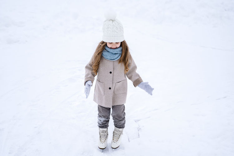 Full length of girl standing on snow covered field