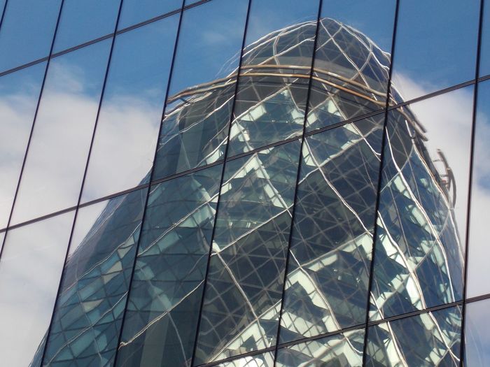Low angle view of glass building against sky