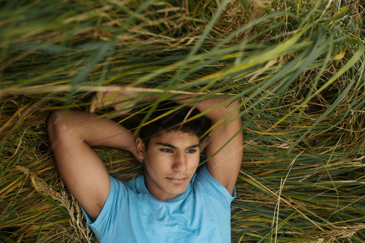 Portrait of young man lying on grass