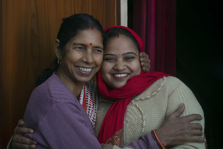 Portrait of smiling mother and daughter at home