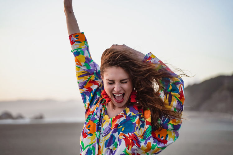 Cheerful woman with multi colored clothing at beach
