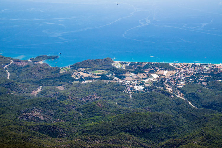 High angle view of land and mountains against blue sky