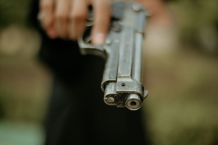 Close-up of person holding gun