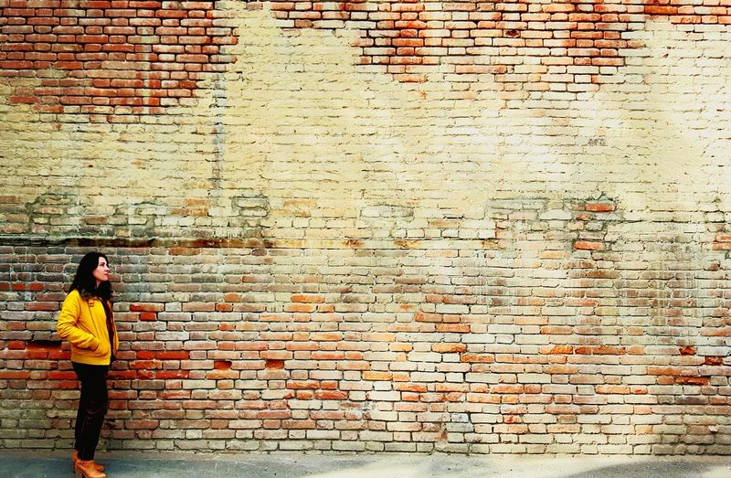 Man standing against brick wall