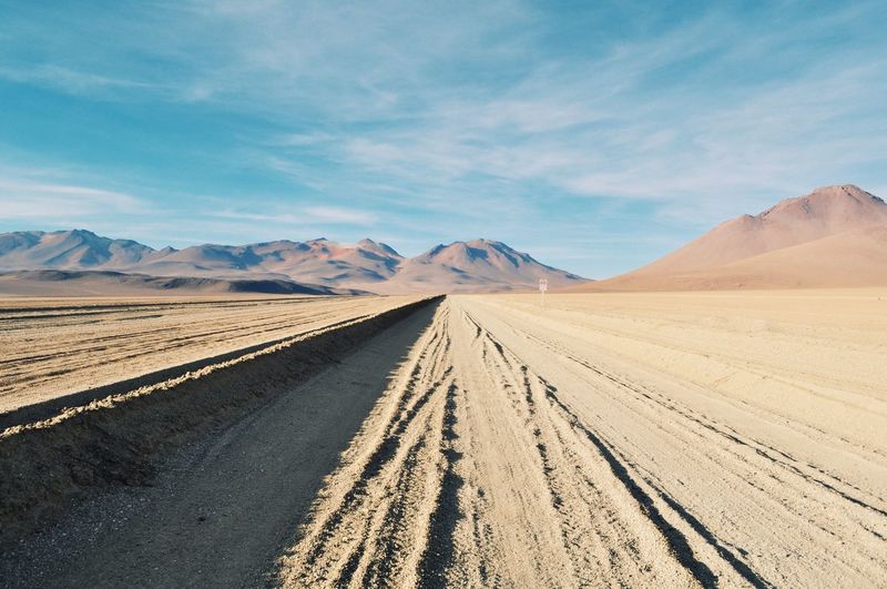Empty road towards sand dunes