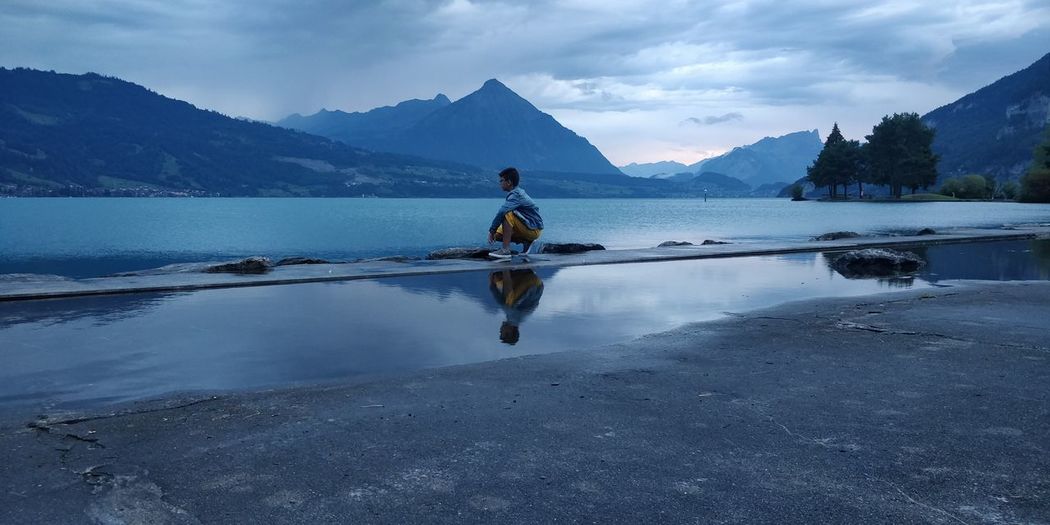 Full length of boy in lake against sky in interlaken- switzerland