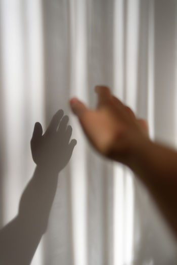 Cropped image of hand against wall