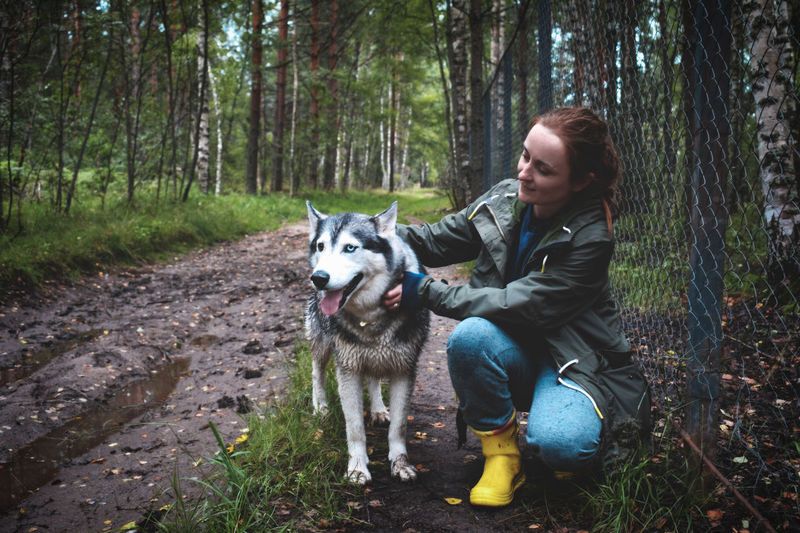 Woman with husky dog in the forest