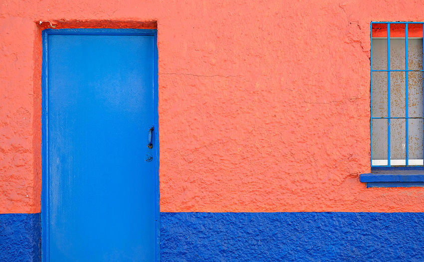Close-up of blue door and red wall 
