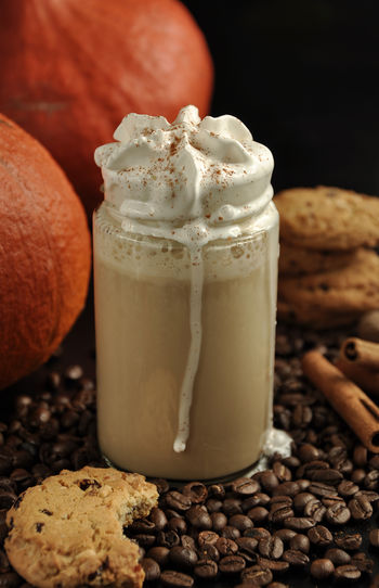 Close-up of pumpkin spice latte and roasted coffee beans