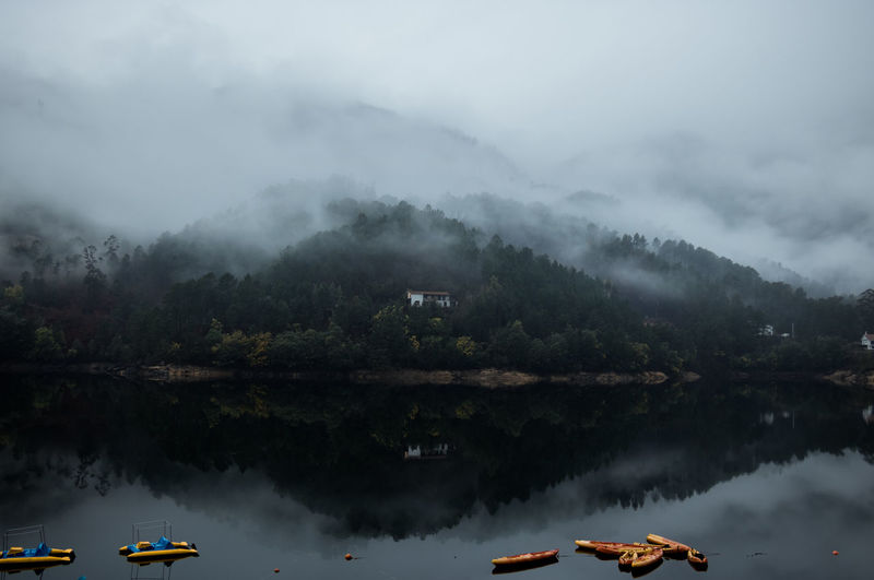 Scenic view of lake against sky during foggy weather