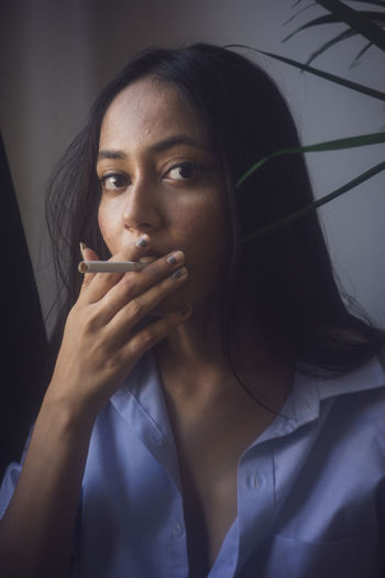 Portrait of beautiful young woman smoking