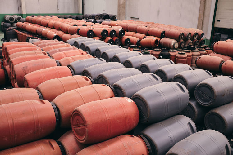 High angle of assorted plastic barrels stored in spacious warehouse in industrial area of factory