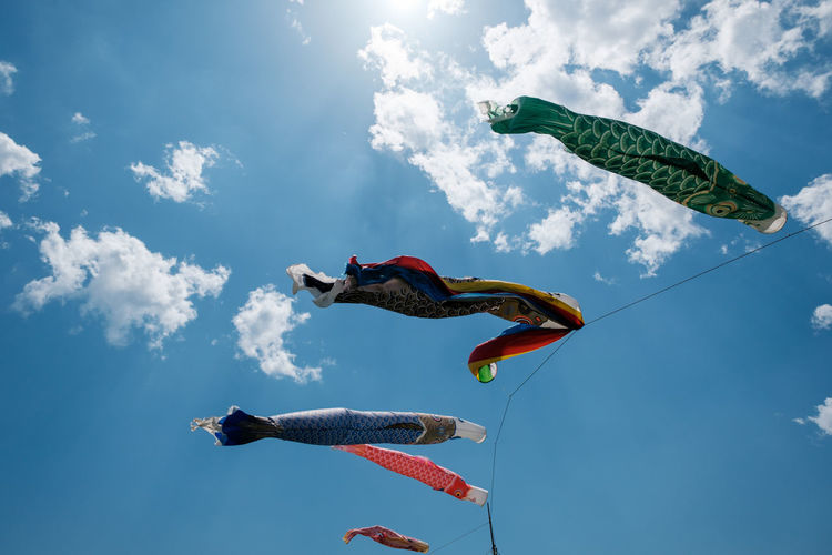 Low angle view of carp streamers flying against sky