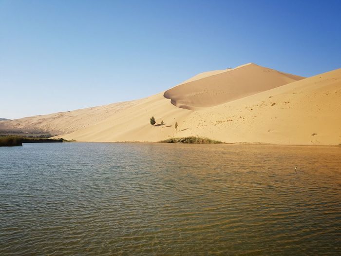 Scenic view of lake against sky at badain jaran desert
