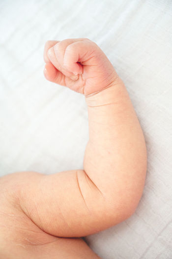 New born baby flexing their arm and hands