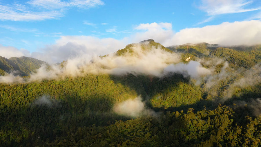 Aerial view of sunrise in the mountains covered with rainforest with clouds. philippines, mindanao.