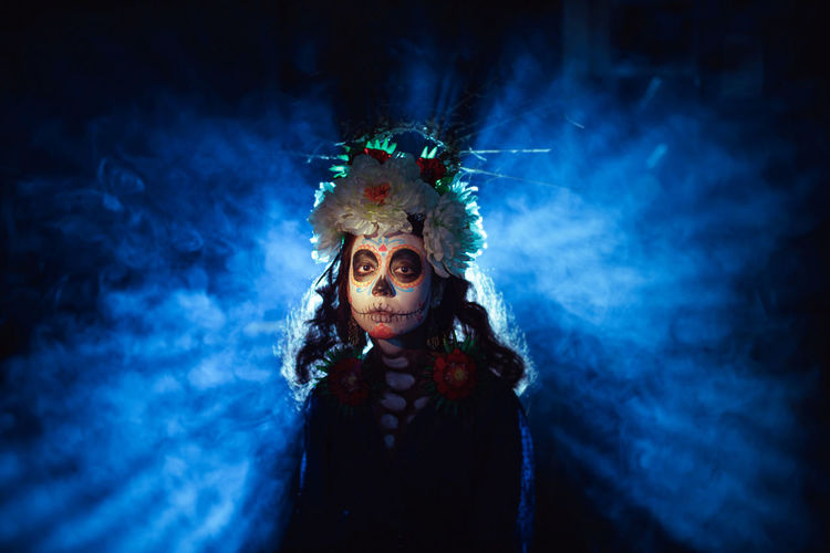 Portrait of woman wearing mask in dark