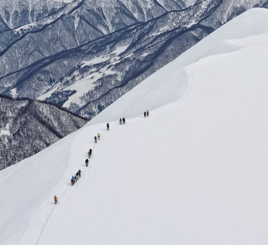 High angle view of people walking on snow covered land