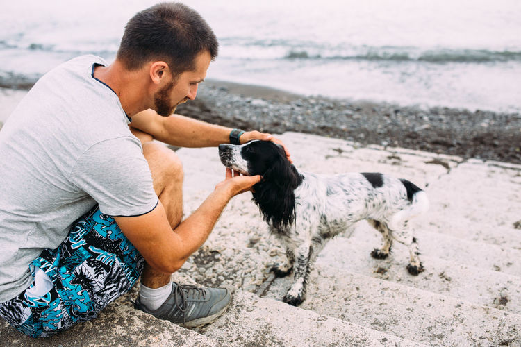 Happy owner of russian cocker spaniel dog, responsibility of caring about pet