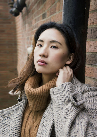 Portrait of young woman wearing warm clothing in city