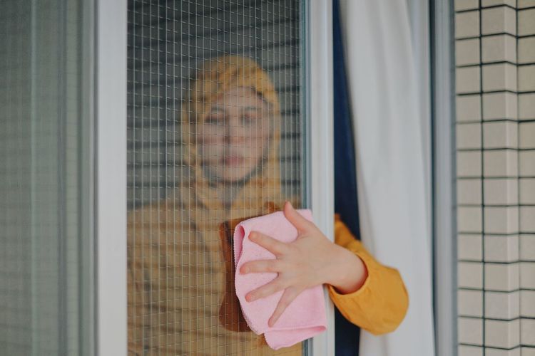 Portrait of woman standing by window