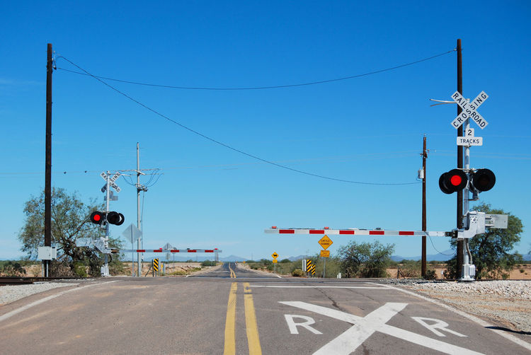 Road signs against clear blue sky