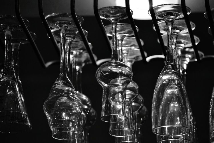 Low angle view of drinking glass hanging from rack in bar