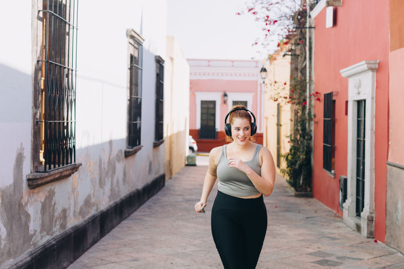 Young woman in sports clothing doing running and stretching exercises in queretaro, mexico