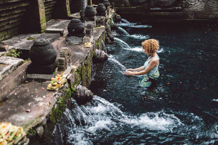 Full length of woman splashing water