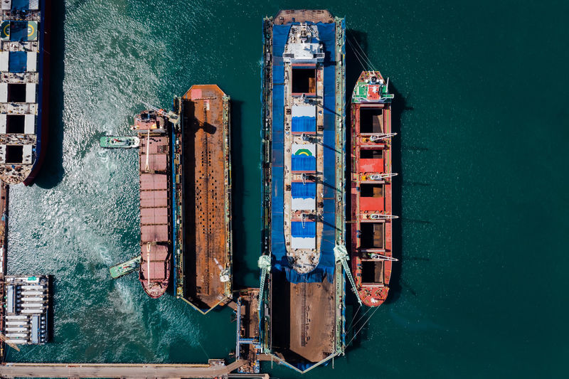 Oil tank ship repairing and maintenance on shipyard dock in sea aerial top view from drone